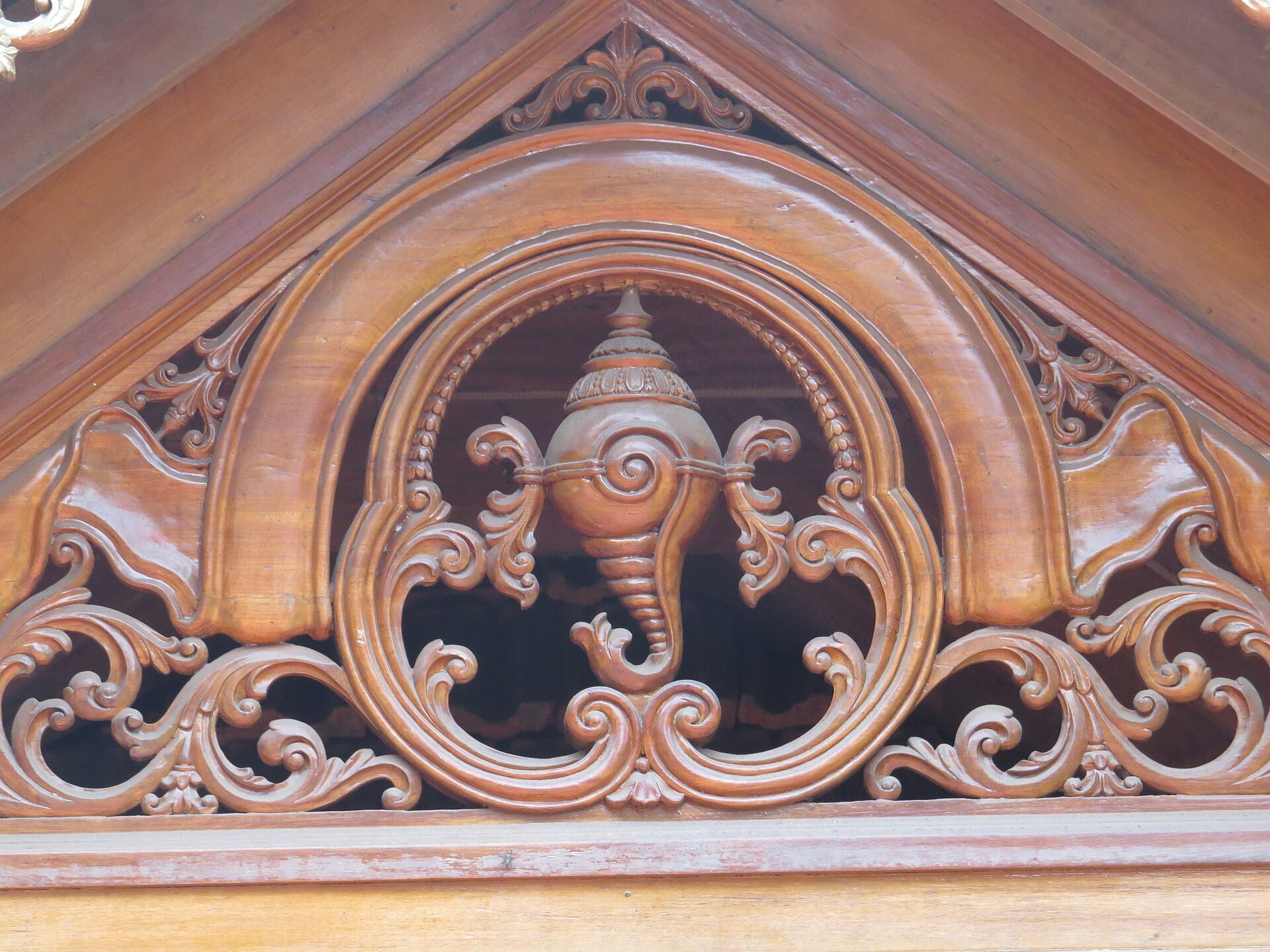 Hand-carved wooden detail inside Kuthiramalika Palace. The 122 carved horses on the eaves give the palace its name.
