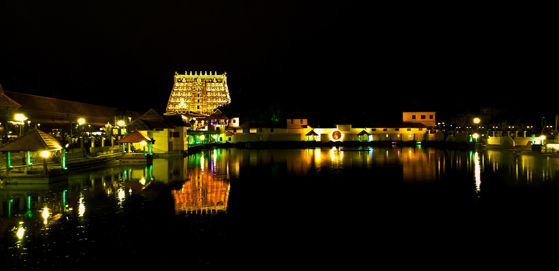 The gopuram of Sree Padmanabhaswamy Temple lit up and reflected in Padmatheertham pond. Note the temple dress code befo…